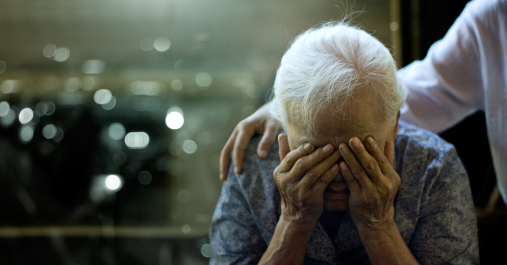 Eldery women suffering with Dementia being conforted by a caretaker