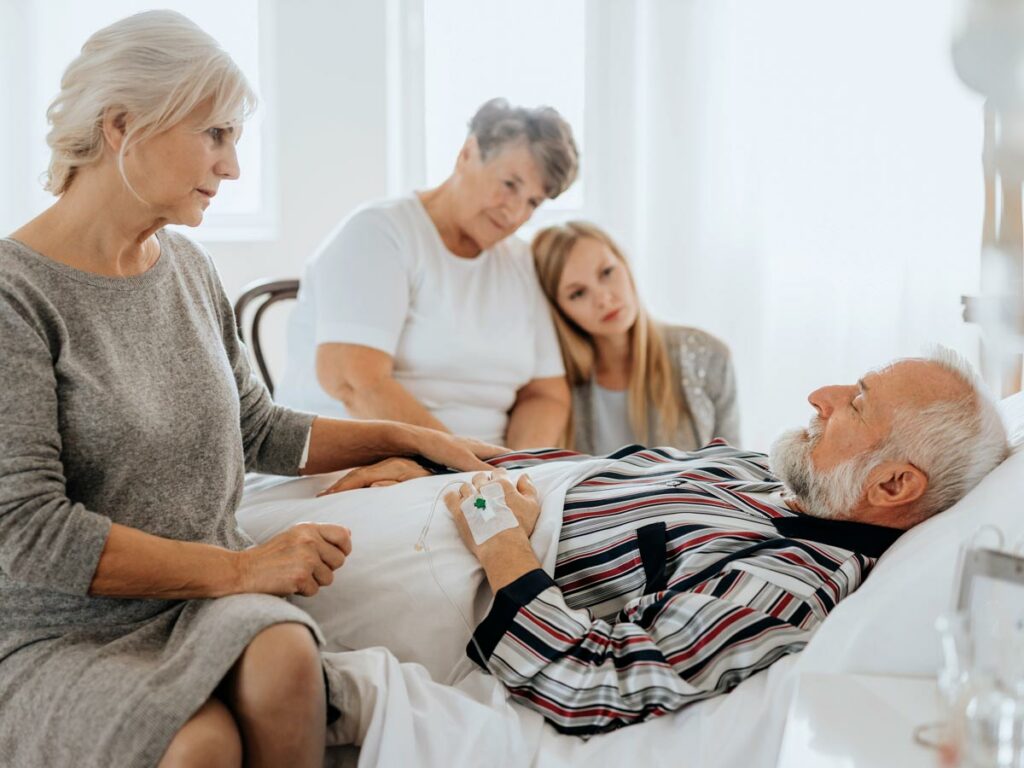 Terminal patient at home, embraced by family - wife, sister, granddaughter - sharing precious time together.