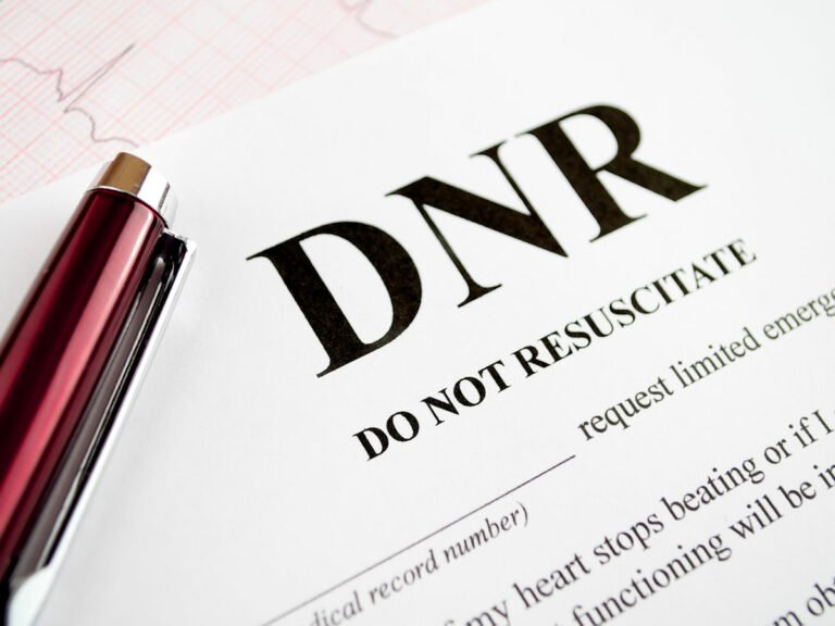 "Medical Decision-Making: A blank Do Not Resuscitate (DNR) form rests on a sterile surface, accompanied by the subtle presence of an EKG test paper and a vibrant red pen in the backdrop. This evocative image captures the gravity of end-of-life choices and the intersection of medical technology and personal preferences."