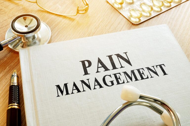 A healthcare setup highlighting a book titled "Pain Management" with medical tools and medication, symbolizing holistic pain relief strategies.
